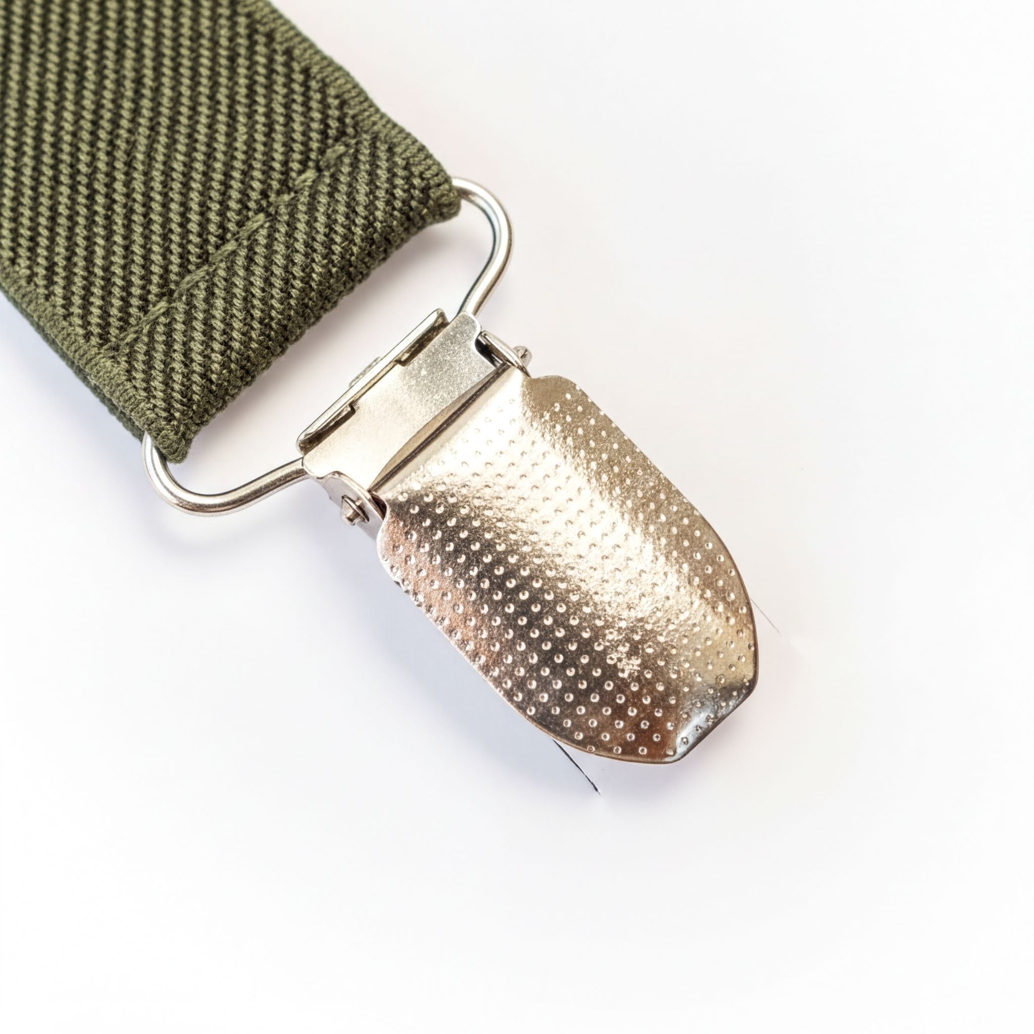 A close-up view of a metal clasp or buckle on a strap or belt, with a textured surface.