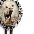 A moose standing in a forest, with a decorative metal frame around it.