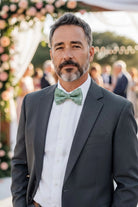 Sage bow tie worn by a man in a suit.