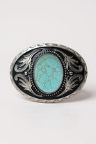 Decorative turquoise belt buckle with turquoise stone and silver detailing on a white background