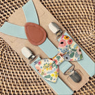 Floral bow tie and suspenders set on a woven surface