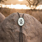 Opossum bolo tie for men and women on a rock with a blurred natural background