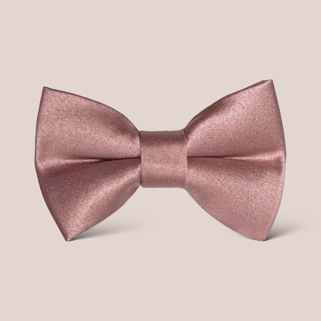 a pink bow tie on a beige background