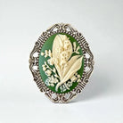 Decorative brooch with floral design on a green background