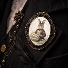 Decorative brooch with a rabbit holding Easter eggs on a dark background