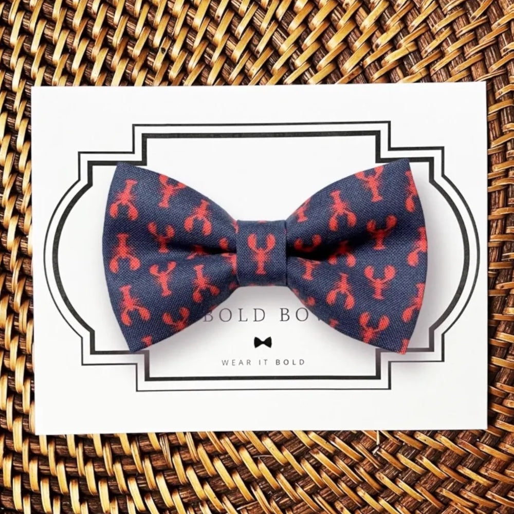 Nautical dog bow tie with navy blue and red lobsters.