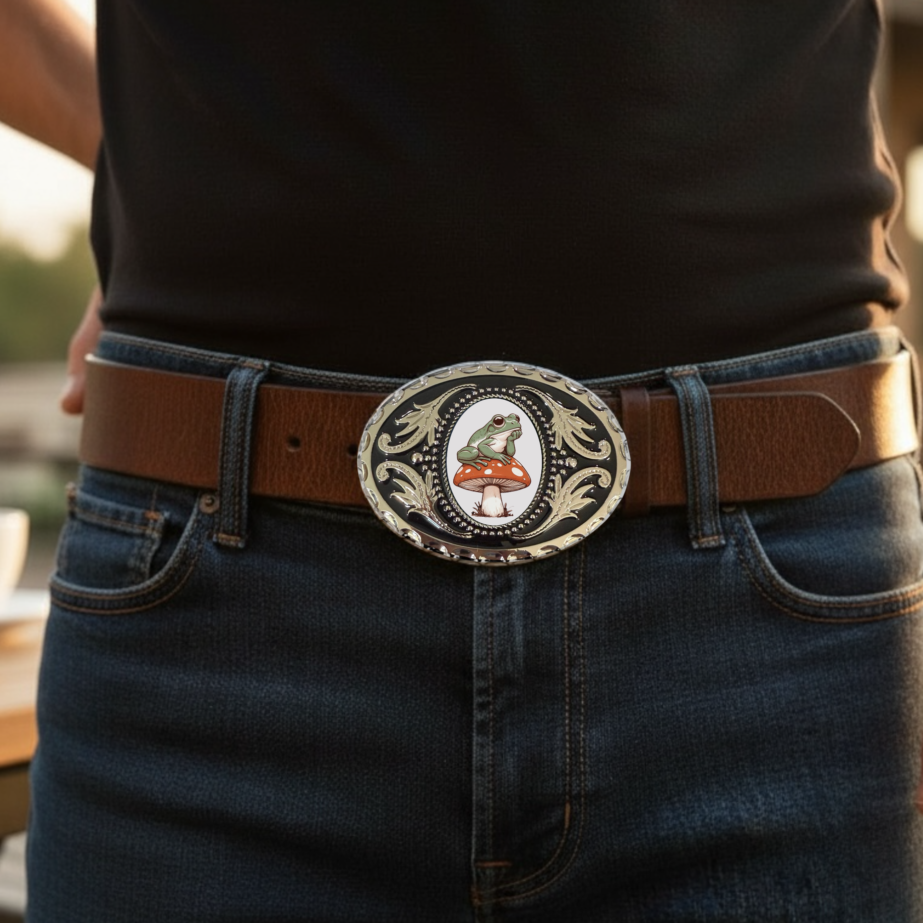 Person wearing a belt with a decorative buckle featuring a frog on a mushroom design.