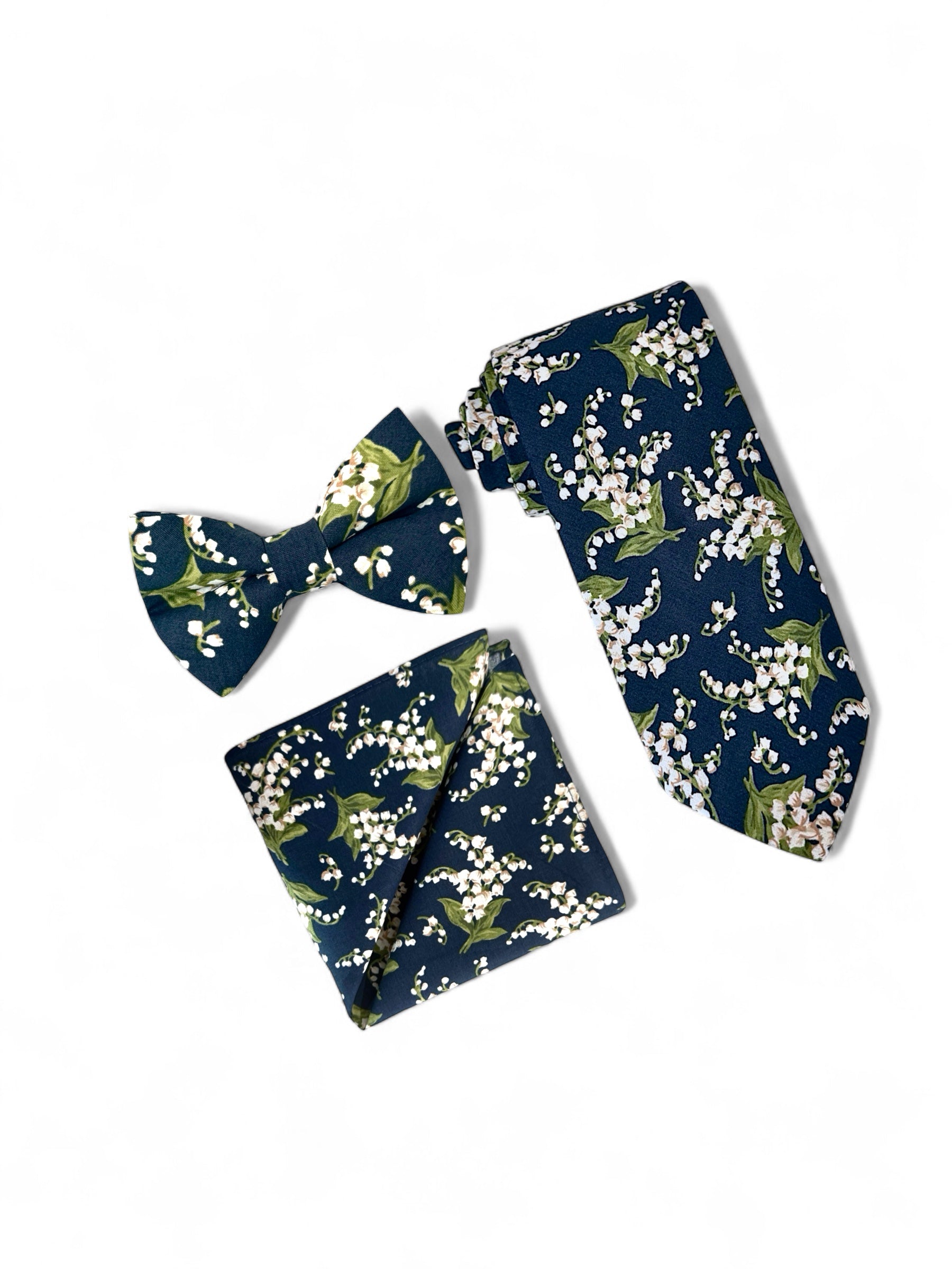 Navy blue and white floral men’s tie, bow tie and pocket square for wedding.