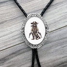 Bolo tie with raccoon wearing a hat and boots design on a wooden surface