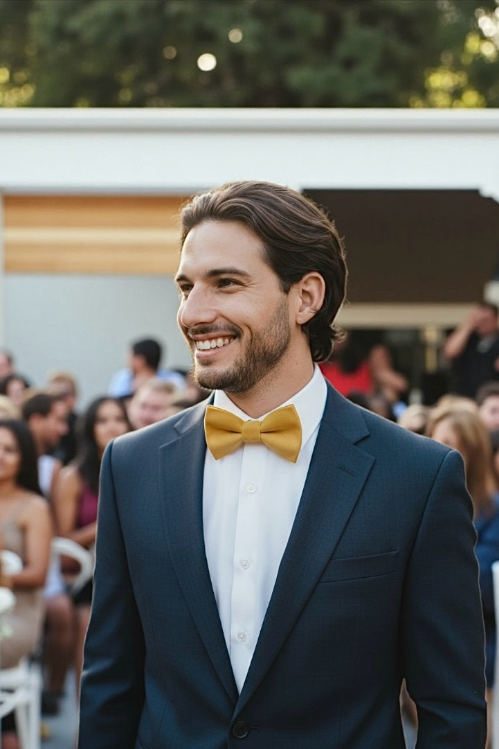 Groomsman at a wedding wearing a mustard yellow bow tie.