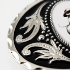 A close-up view of a decorative metal piece with a black and silver design, featuring intricate patterns and textures.