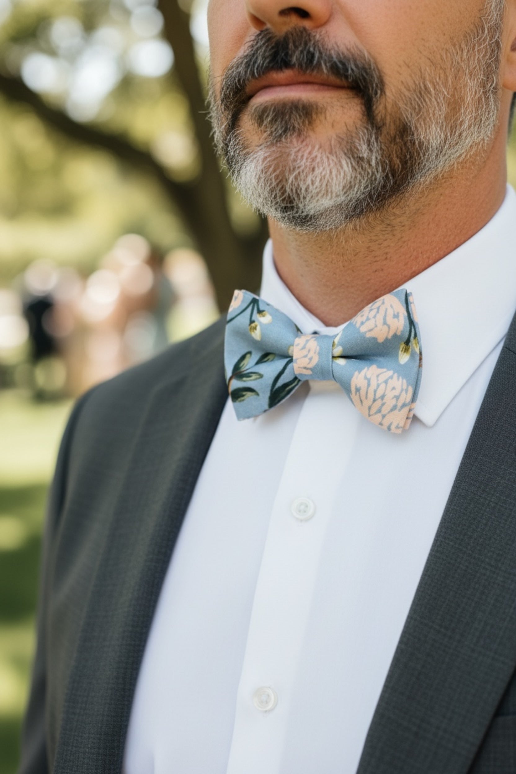 Dusty blue floral bow tie worn by a groomsman in a wedding.