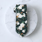 Floral groomsmen ties or wedding accessories in emerald green and white.