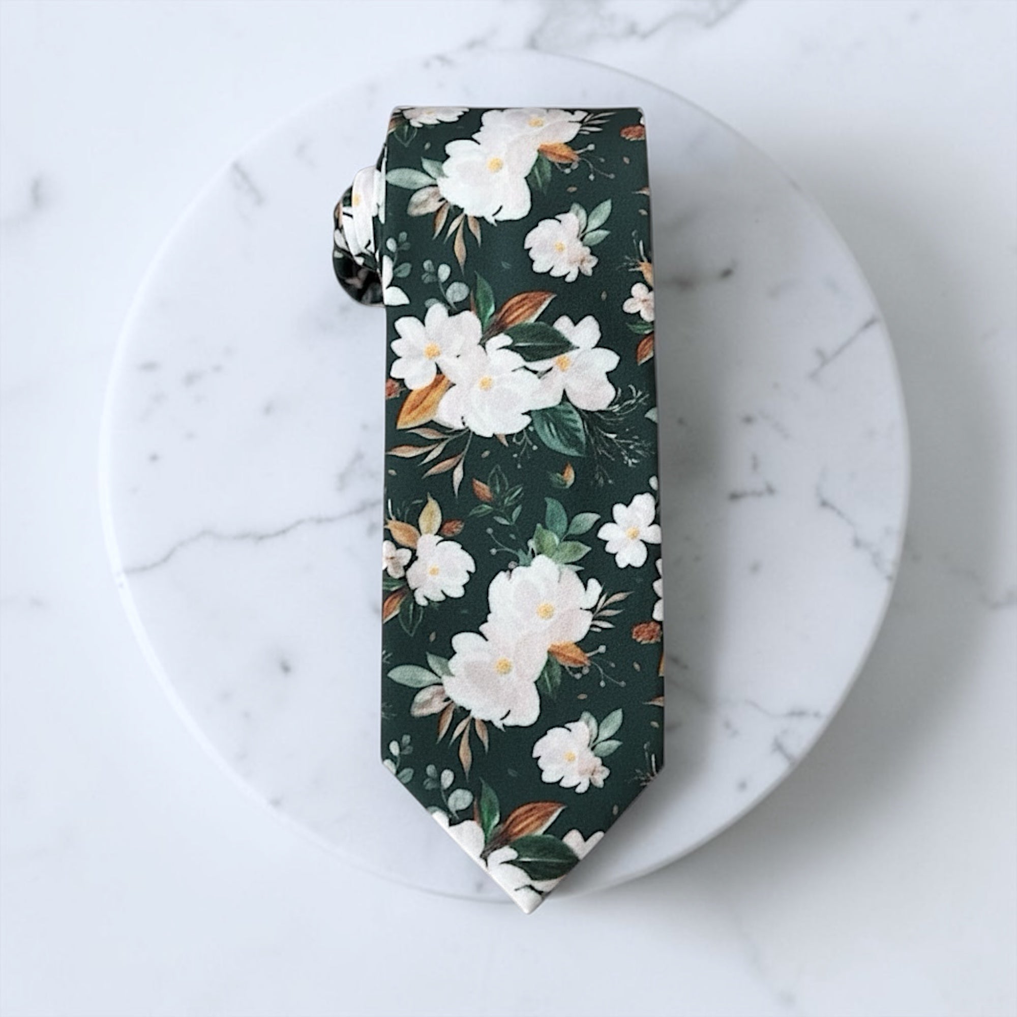 Floral groomsmen ties or wedding accessories in emerald green and white.