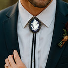 Man wearing a dark suit with a Navy Lily of the Valley Bolo Tie- Cowboy Tie Western String Tie featuring a white floral design.