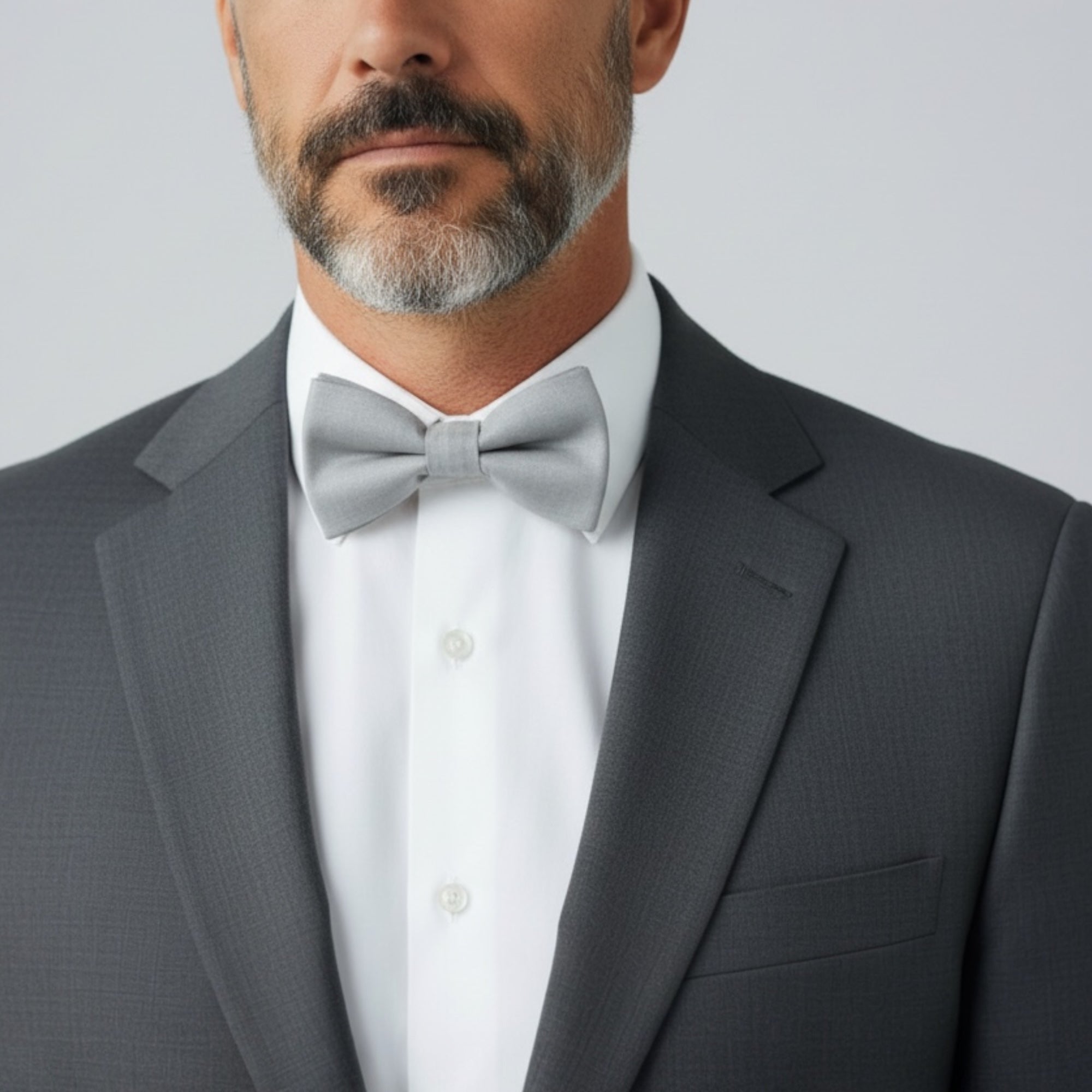 Man wearing a slate gray bow tie as a groomsman in a wedding.