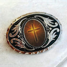 a decorative oval-shaped object with a cross design on it.