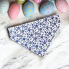Floral dog bandana for Easter on a marble surface with colorful Easter eggs in the background