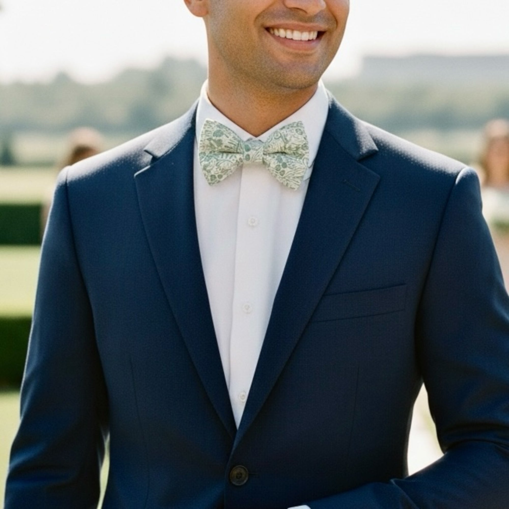 Groomsman in a Sage green bow tie with flowers at a wedding.