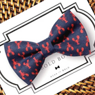 Navy blue dog bow tie with lobster patterns on a brand box
