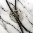 Silver bolo clasp on black leather cord