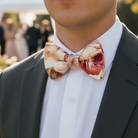 Size chart for pre-tied bow ties from The Bold Bow Tie detailing measurements across three sizes. Small is 3.5 inches wide and recommended for ages 6 months to 5 years. Medium is 4 inches wide and recommended for ages 6 to 12 years. Large is 4.5 inches wide and recommended for ages 13 years and up. Visual icons illustrate the relative sizes with horizontal arrows showing that width is measured from wingtip to wingtip. Bottom text notes that all bow ties are pre-tied and ready to add to your outfit.