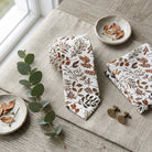Wedding autumn floral men’s tie with burnt orange and brown leaves on a white background surrounded by soft props such as a eucalyptus leaf by The Bold Bow Tie.