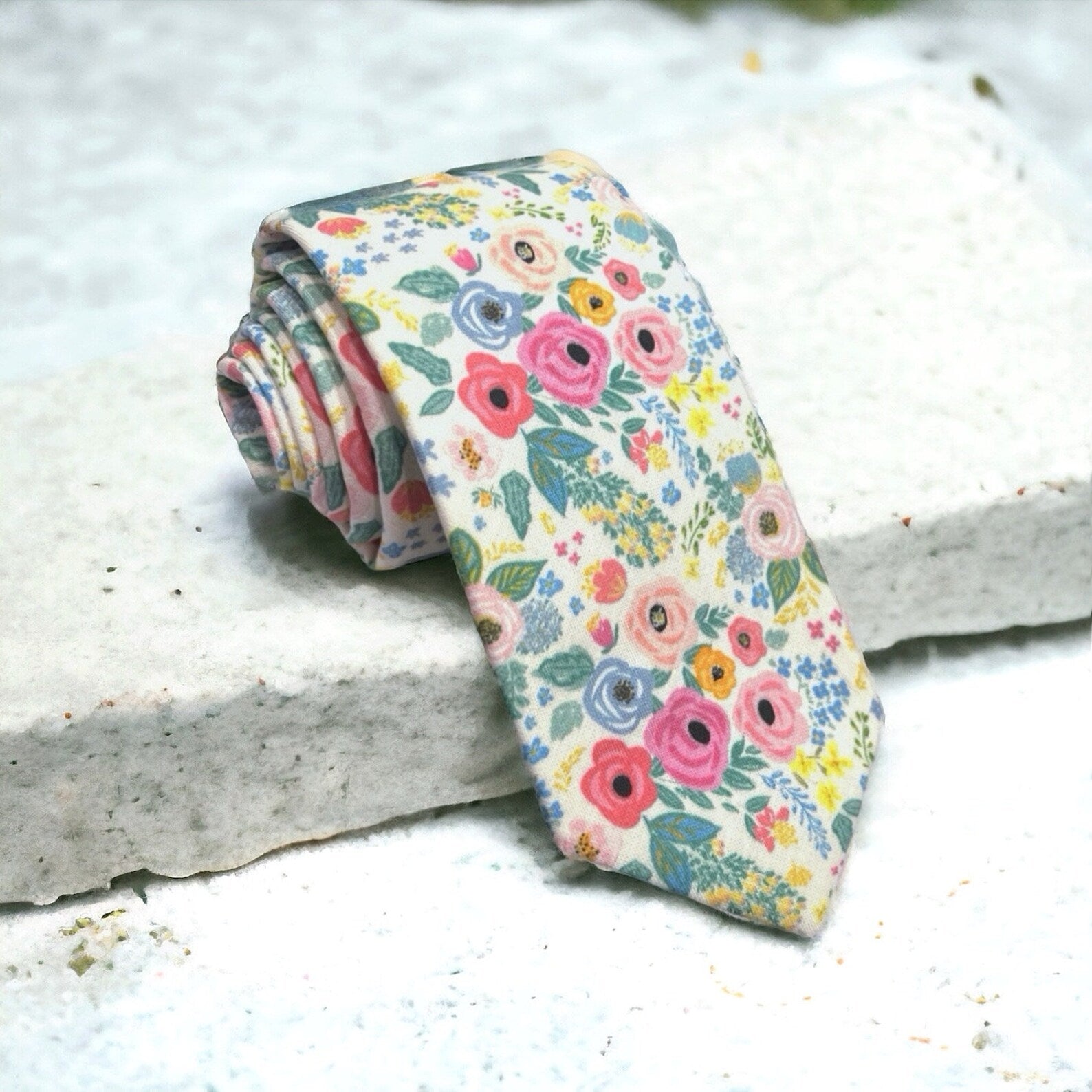 a tie with flowers on it sitting on a ledge