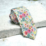Load image into Gallery viewer, a tie with flowers on it sitting on a ledge
