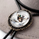 A decorative bola with a clear glass center, featuring an illustration of a bird in flight.
