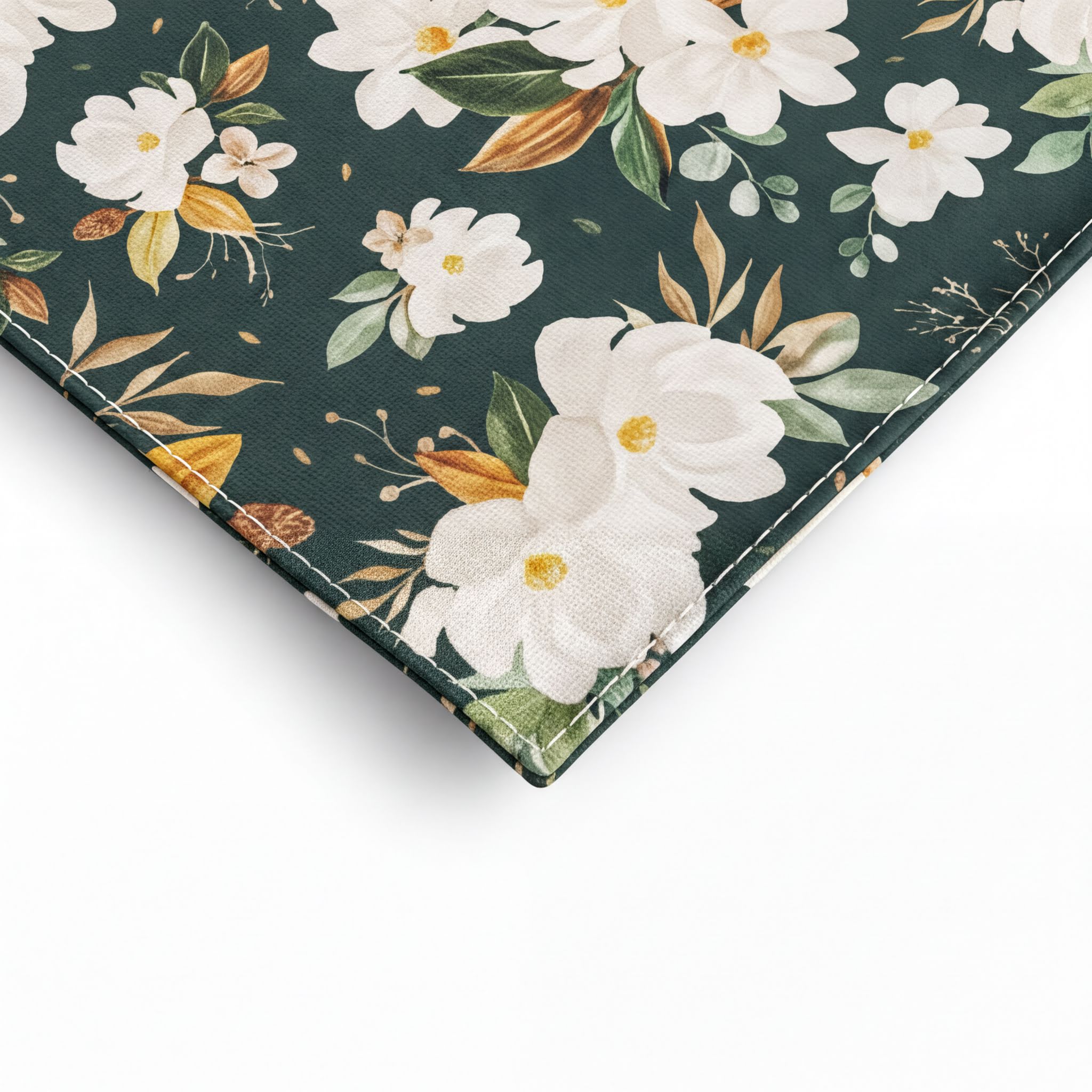 a close-up view of a fabric pocket square with a floral pattern, including white flowers and green leaves. The fabric appears to be a dark green color, and the pattern is intricate and detailed.