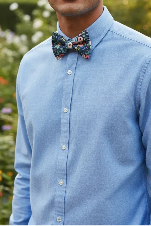 Floral bow tie for men worn by a man at an outdoor wedding.