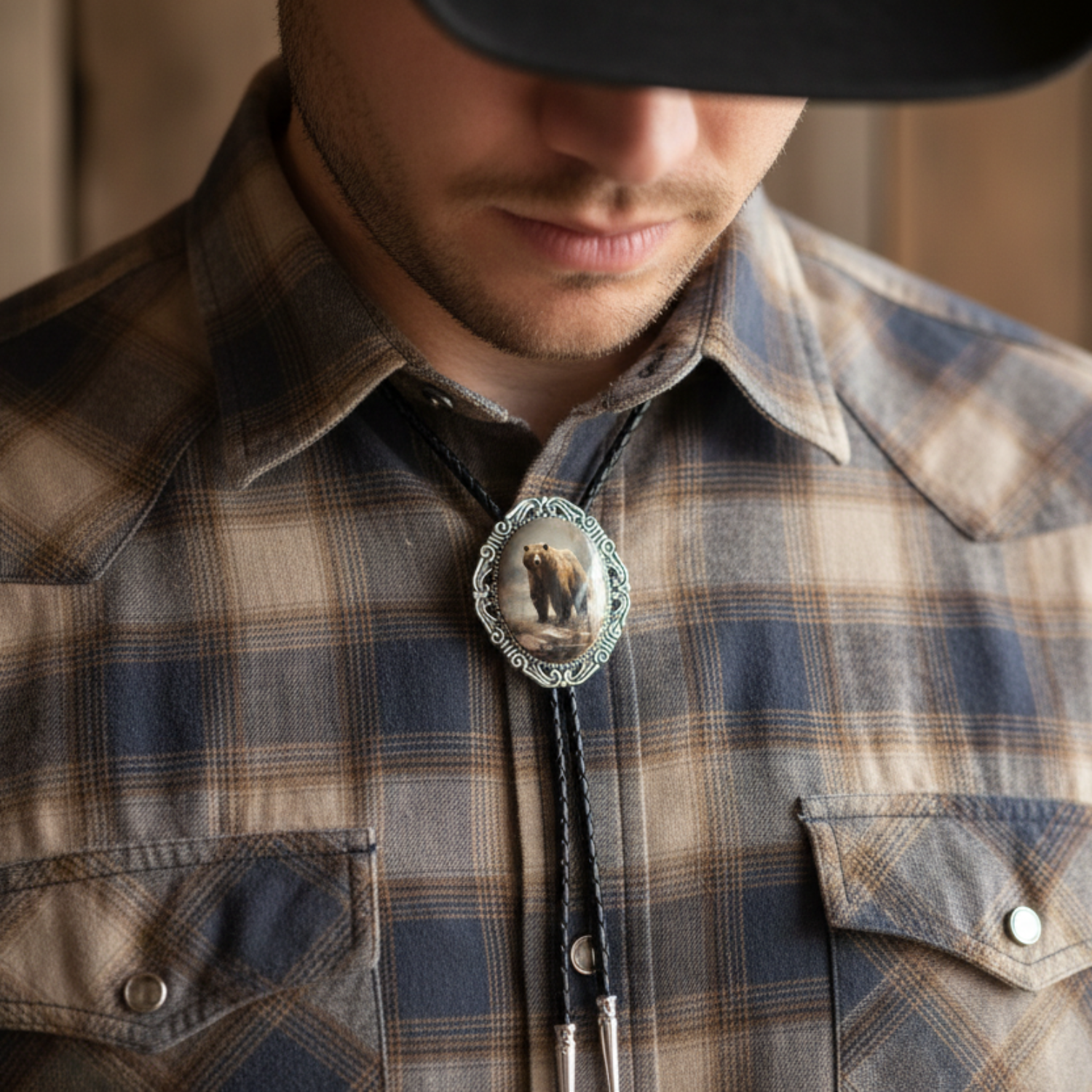 Bear bolo tie worn by a cowboy against a wooden panel background