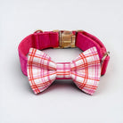 Plaid pink dog collar with a pet bowtie on a light gray background