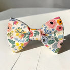 Floral bowtie for men, kids and babies on a white wooden table.
