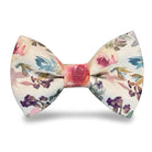 Pre-tied watercolor floral bow tie with pink roses and purple flowers on a light cream background.