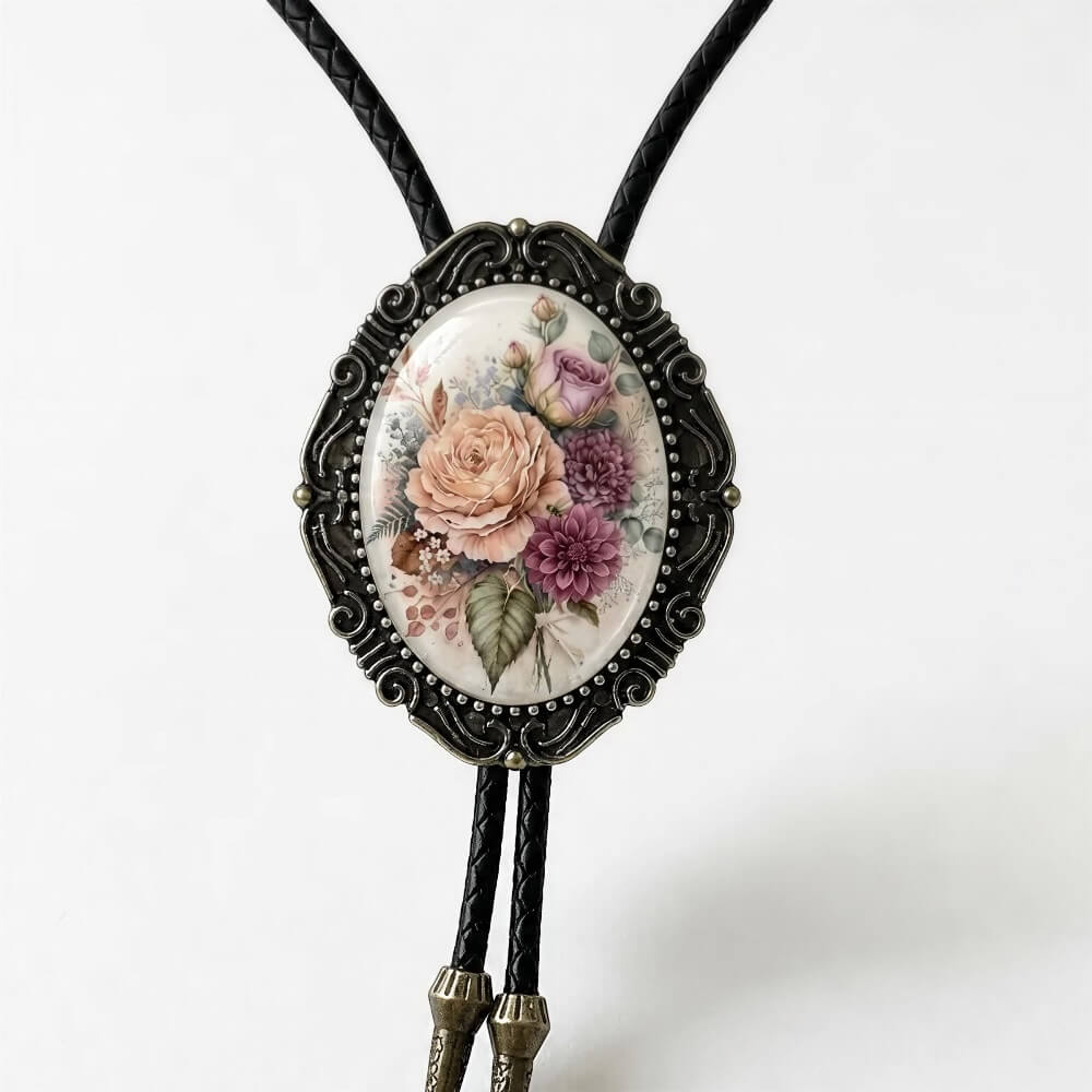 A decorative pendant featuring a floral design on a white background, with a black metal frame surrounding the oval-shaped piece.