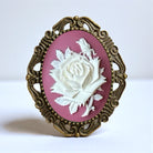 Cameo with white rose and gold frame on pink background