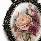 A close-up image of a decorative pendant featuring a floral design with roses, chrysanthemums, and other flowers.