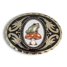 Decorative frog belt buckle with a frog and mushroom design on a black and silver background