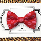 Red Valentines Day dog bow tie with pink lip prints on a white card with 'Wear It Bold' branding.