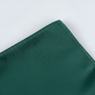 A close-up view of a dark green fabric, possibly a napkin or cloth, with a small, neatly sewn seam running along the edge.