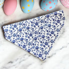Blue floral fabric on a marble surface with colorful Easter eggs in the background