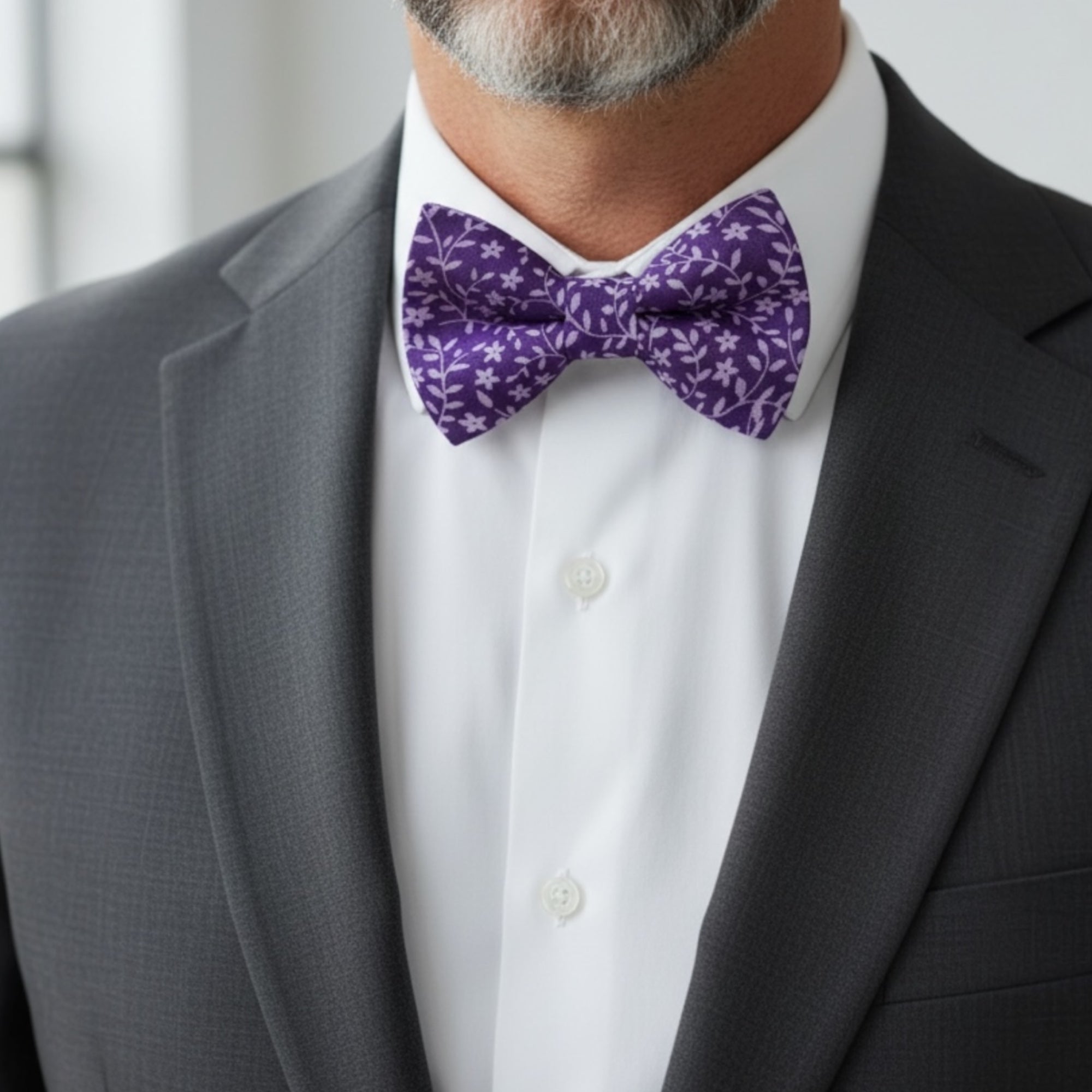Groomsman wearing a purple floral bow tie for a wedding.