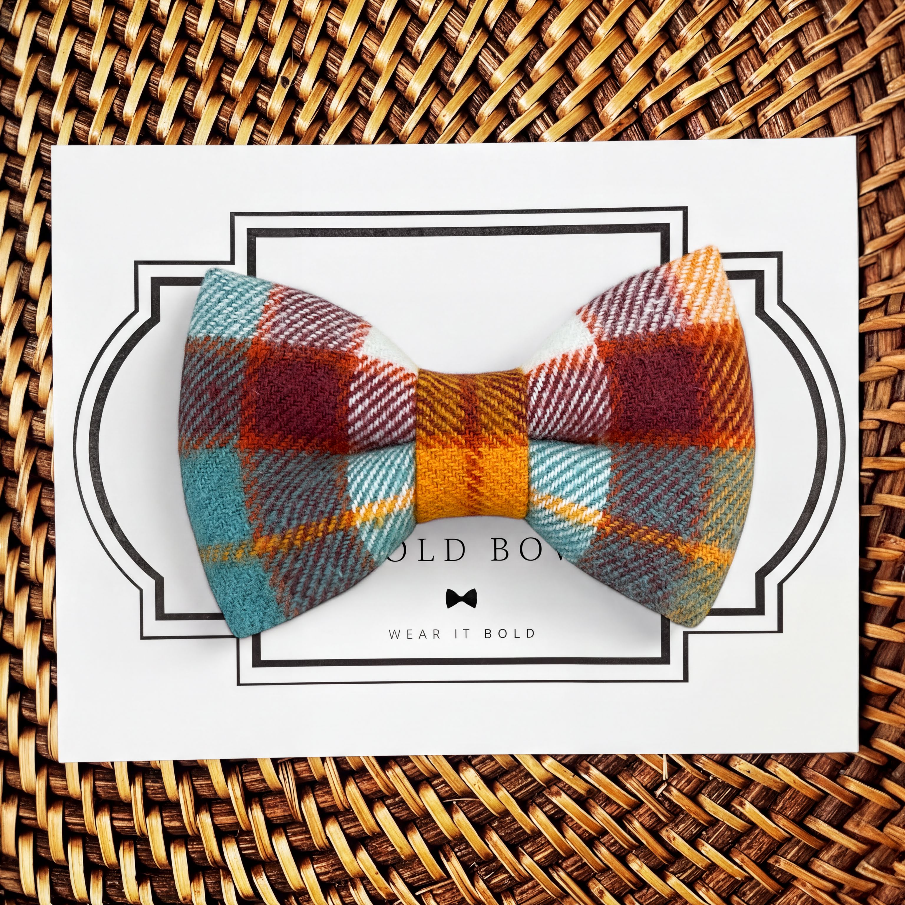 Product graphic showcasing the back of a pre-tied bow tie in a red and black buffalo plaid pattern, resting on a rustic wood surface. Two black elastic loops are attached to the center knot to slide onto a pet collar. Overlay text reads: Back of Bow Tie (may not be actual bow tie in listing).