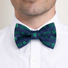 St. Patrick’s Day Navy blue bow tie with green 'Irish' text and shamrock patterns worn by a person.