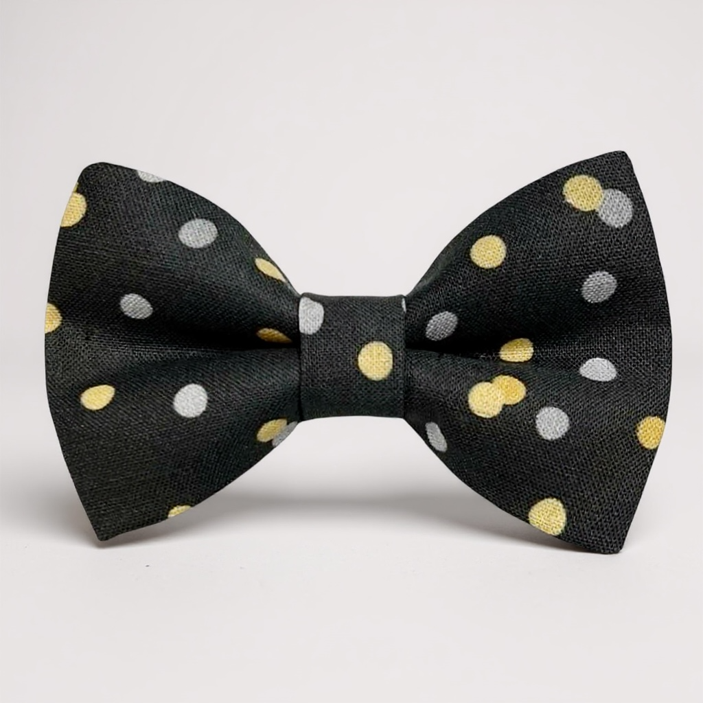Black bow tie with gold and silver polka dots on a white background