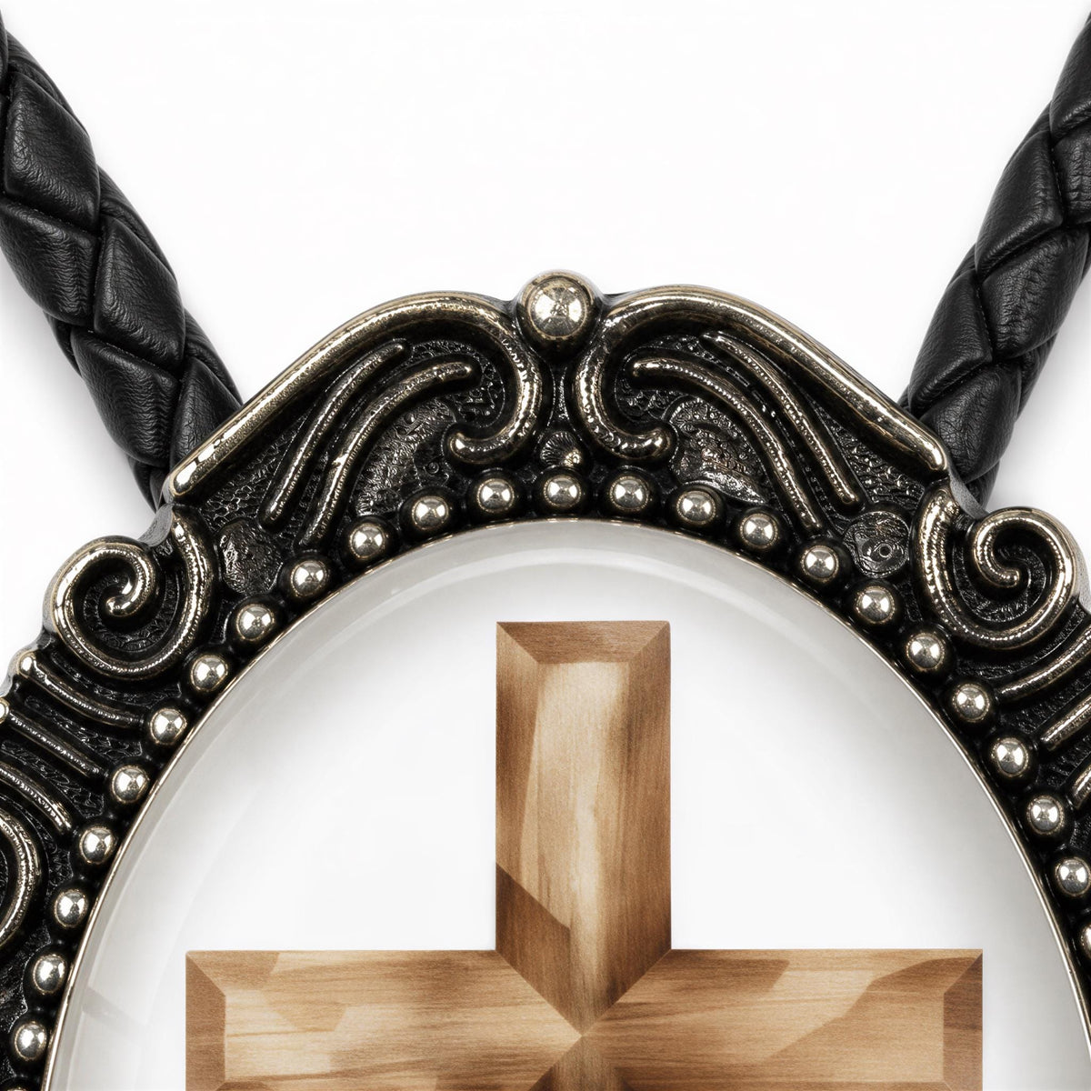a close-up view of a decorative cross pendant with intricate metalwork and a wooden cross at its center.