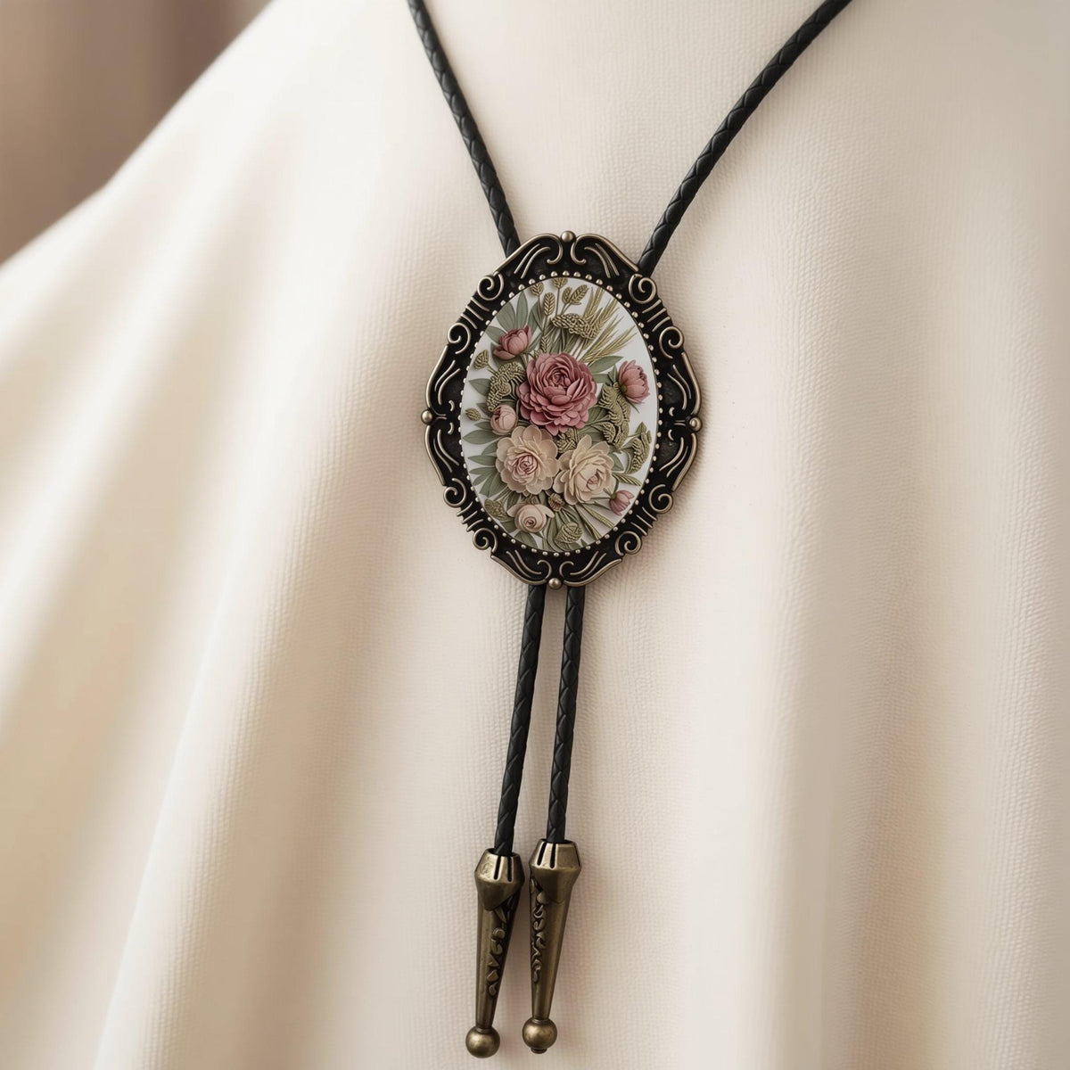 A close-up of a decorative pendant necklace with a floral design on a green velvet background.