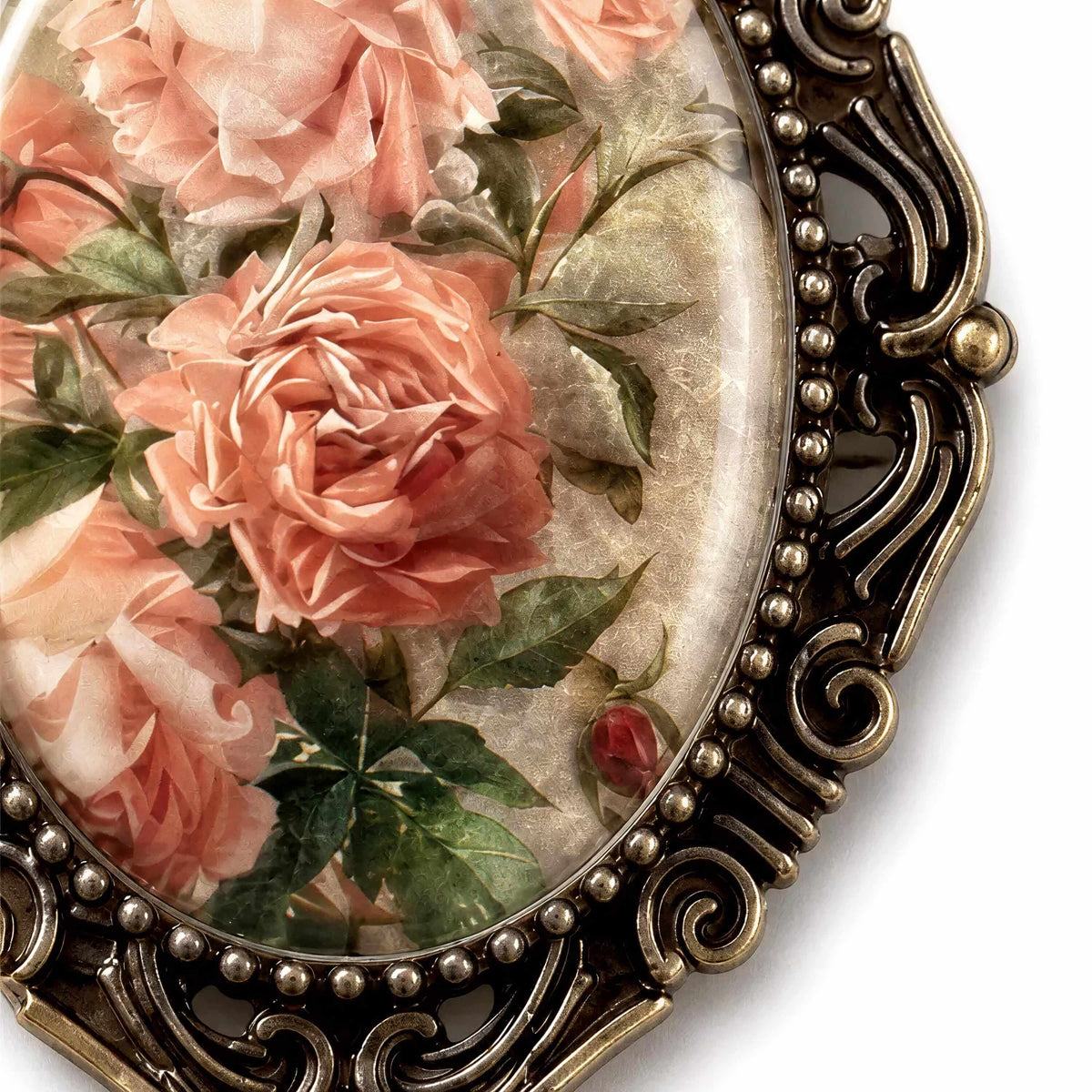 a close-up view of a decorative oval frame with a floral design, including pink roses and green leaves.